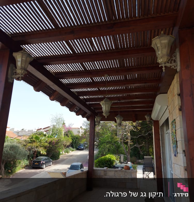 פרגולה מעץ עם מנורות תלייה על מרפסת